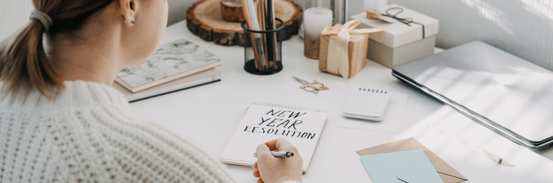 new year health with TCM - woman writing new year goals on notepad at desk